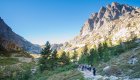 Group of hikers trekking through Corsica’s rugged mountain trails under clear blue skies.