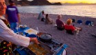 Guides and guests on a outfitted sea kayaking tour cooking dinner on a beach in Baja California Sur