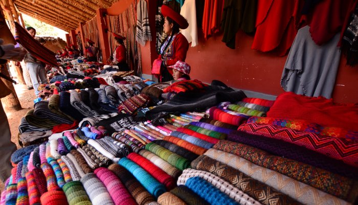 A mom and daughter selling handmade fabric crafts at a craft market in Peru.