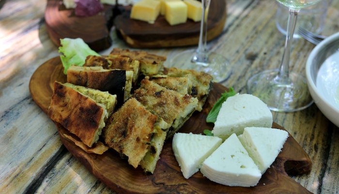 A wooden platter with Albanian bread and cheese.  