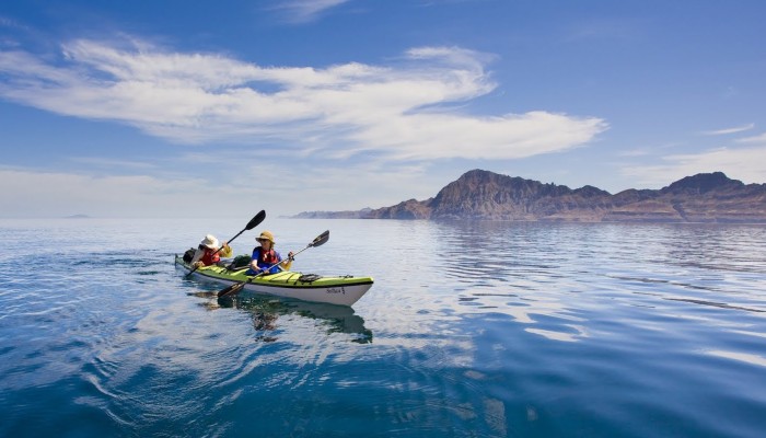 Tandem sea kayak paddling away from the islands of Loreto Bay on the Gulf of California